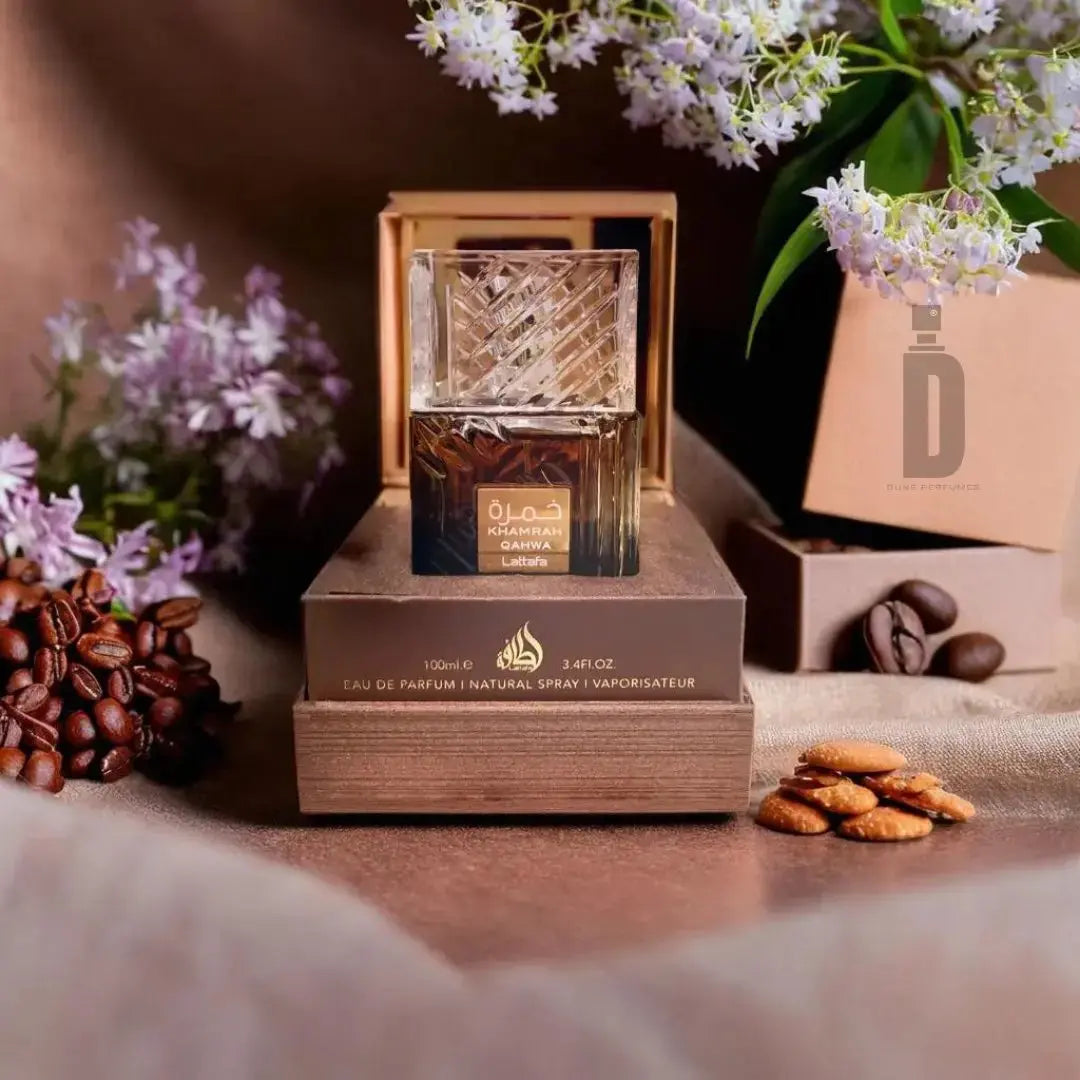 Perfume bottle on a wooden stand with flowers, coffee beans, and cookies in the background